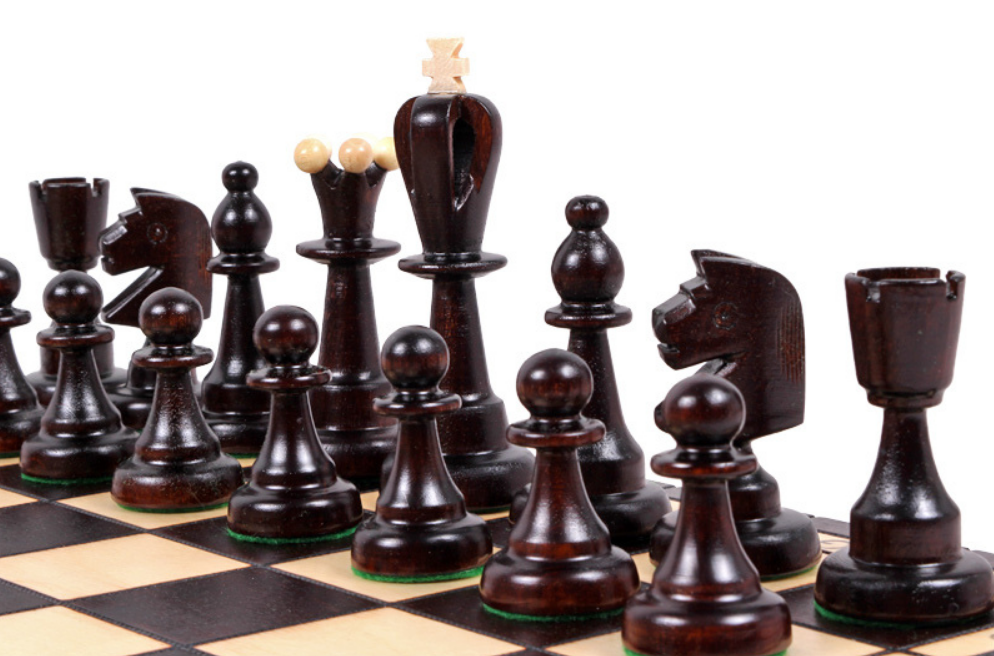 Piezas de ajedrez negras Virtus Staunton rey 100 mm colocadas sobre tablero de madera
